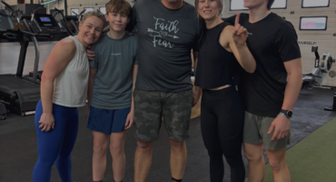Active family smiling together inside City Fit Shop gym in Edmonton Alberta